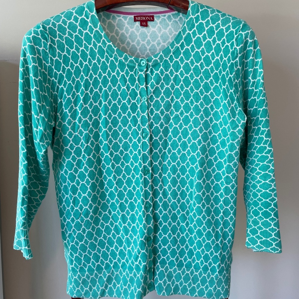 Cardigan in a teal and white quatrefoil pattern